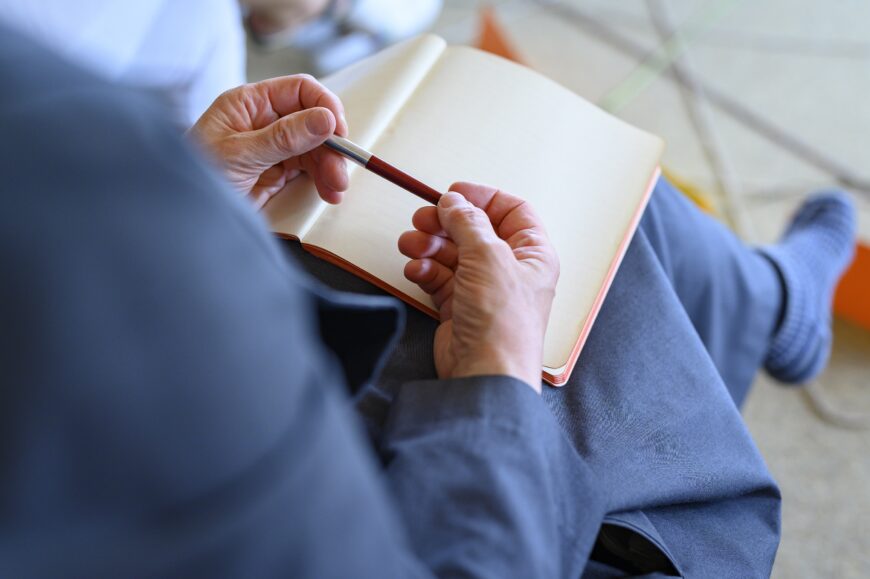 Leeres Notizbuch mit Stift von Frau gehalten