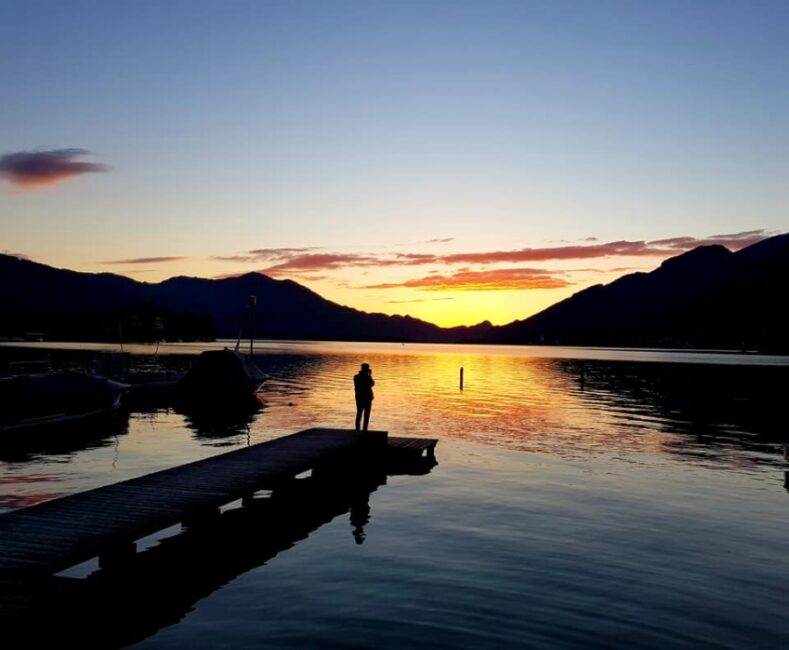 Mensch auf Steg am See